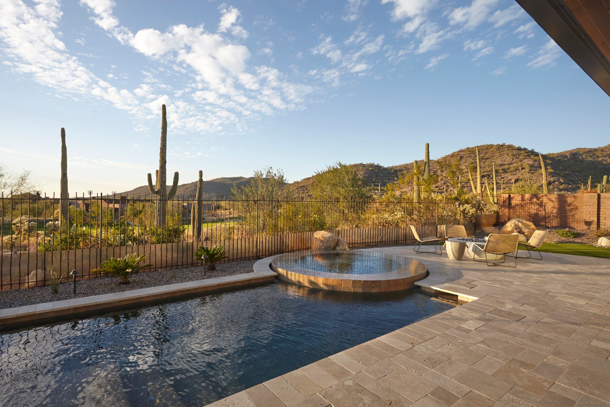 Pool terrace with a spillover spa, lounge seating and mountain views