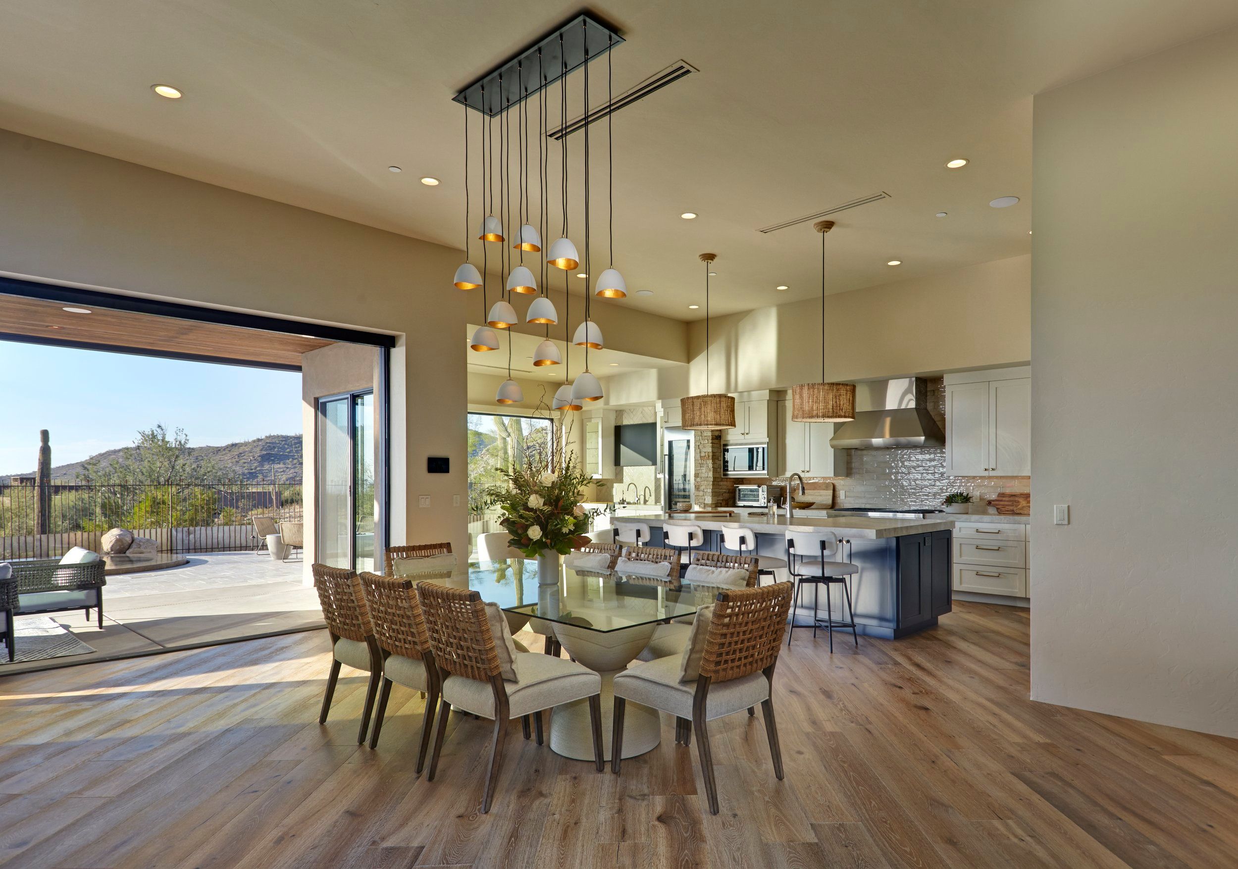 Dining area and kitchen with a cluster pendant light and sliding doors to the patio