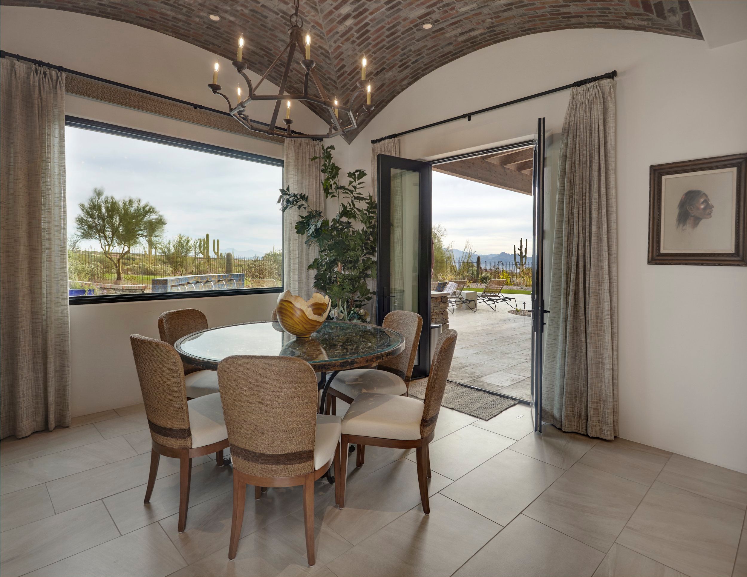 Breakfast room with a round table under the brick vault and doors open to the patio