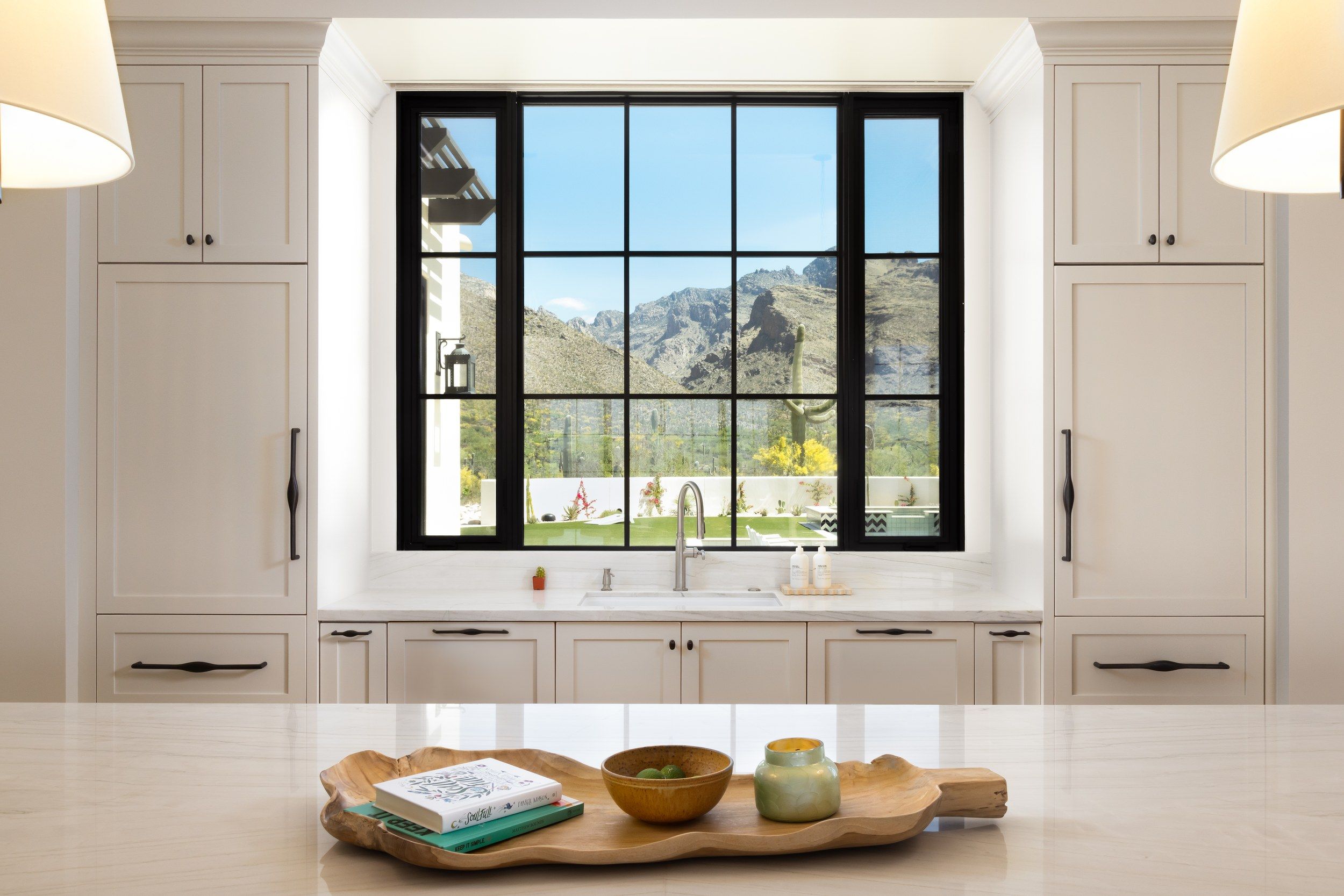 Kitchen sink beneath a steel-framed window looking out to the mountains