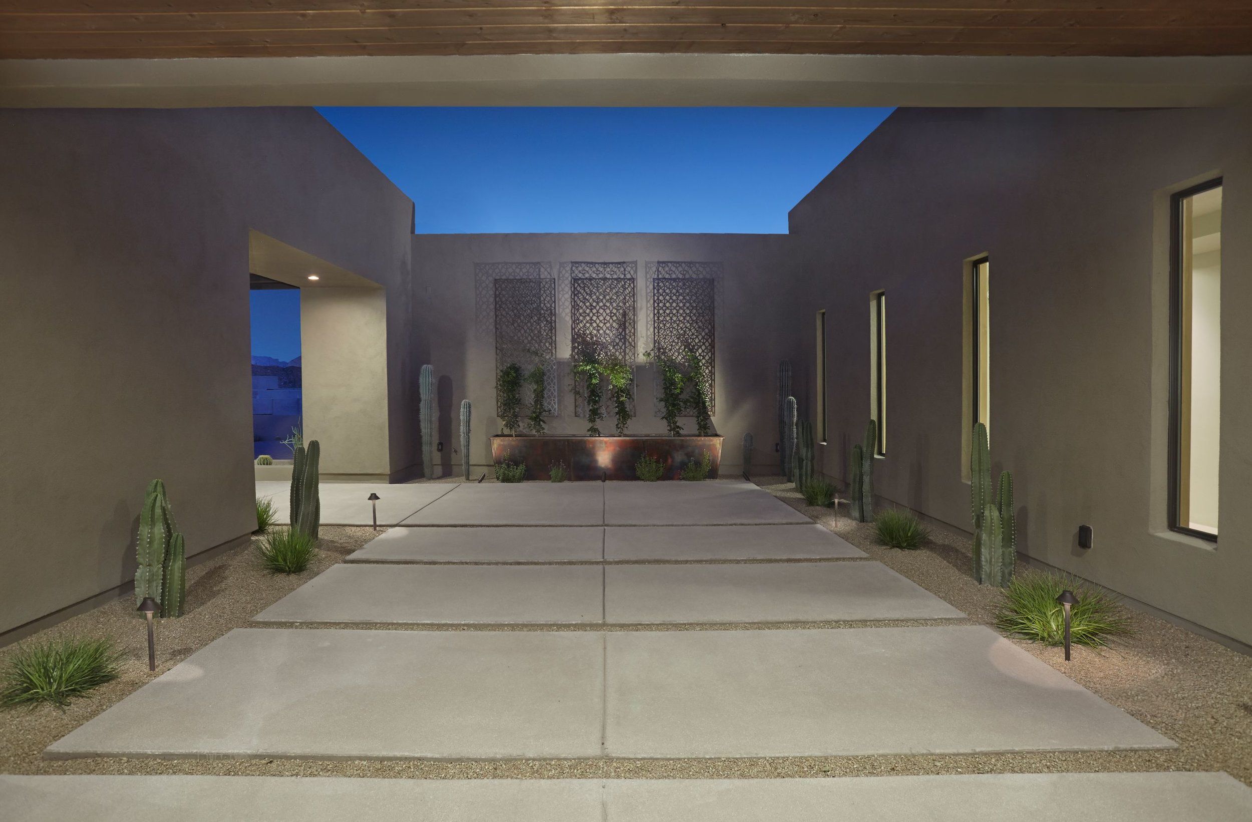 Walled entry court with a decorative screen, planters and slot windows