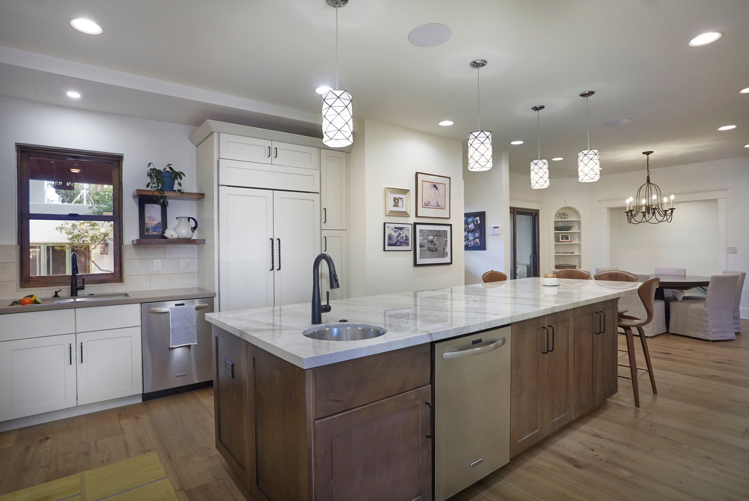 Kitchen island with a quartz top, pendant lighting and integrated refrigeration