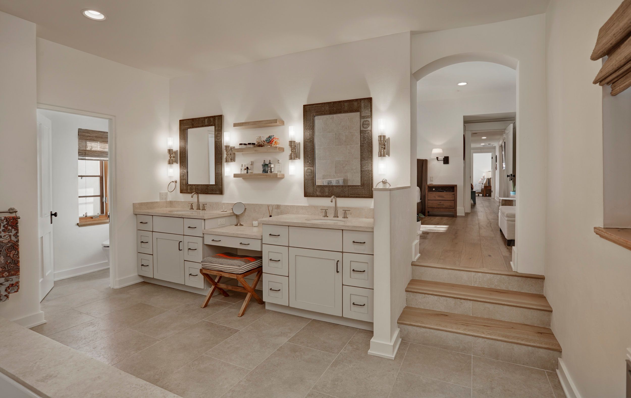 Bathroom with twin vanities, framed mirrors and an arched doorway