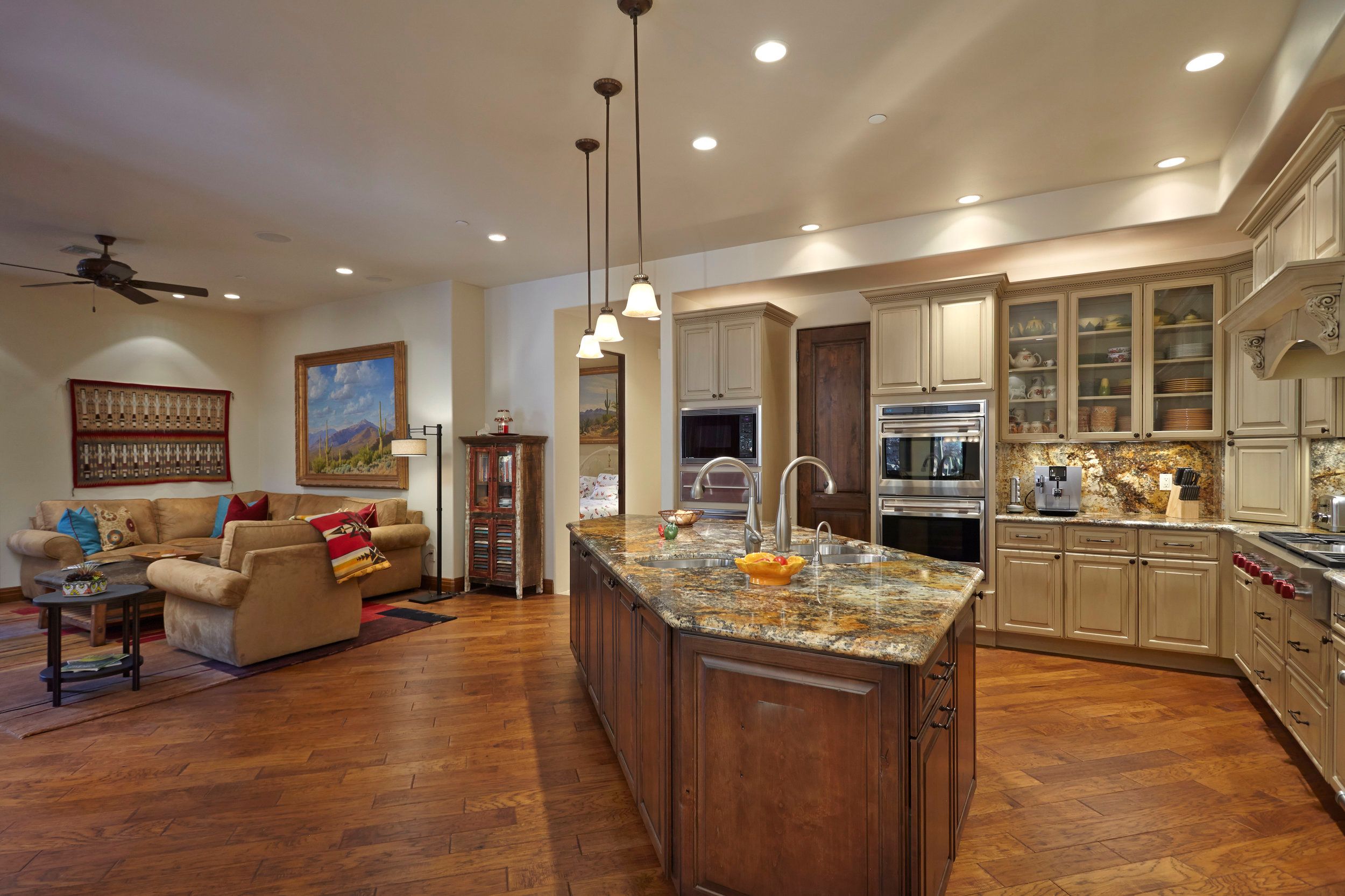 Kitchen island and cabinetry opening to the family room