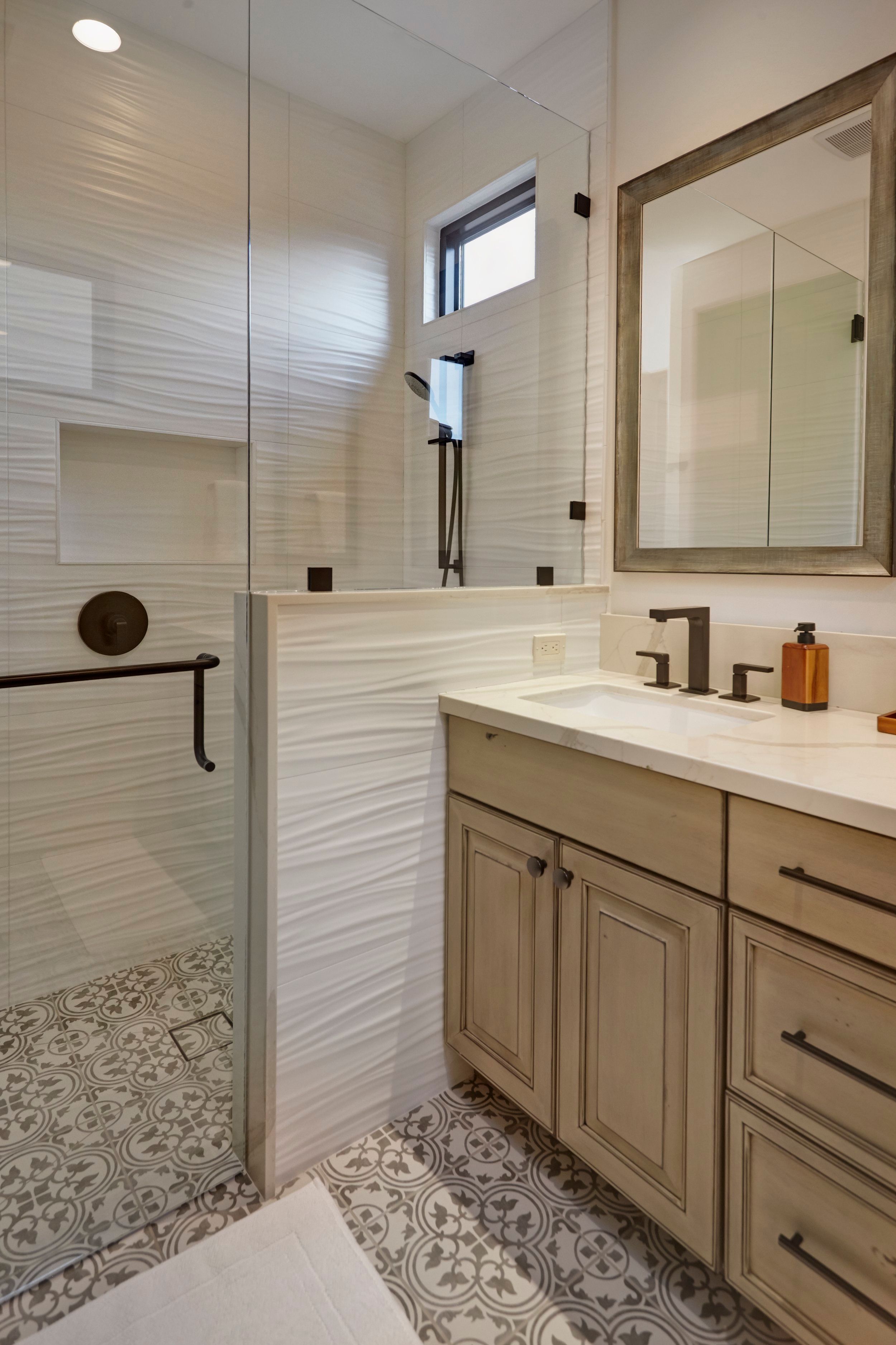 Guest bathroom with a walk-in tiled shower, limed oak vanity and patterned floor tile
