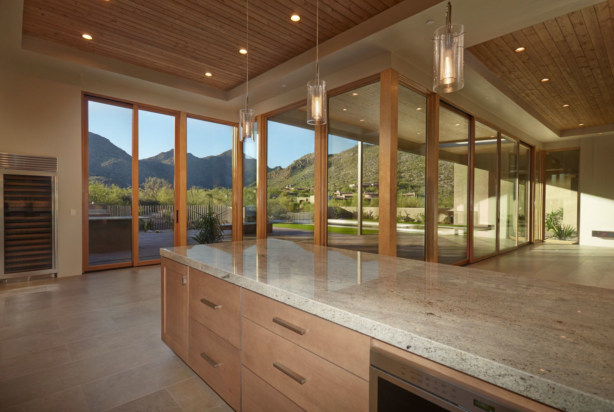 Great room with a wood-plank ceiling and a wall of sliding glass onto the mountains