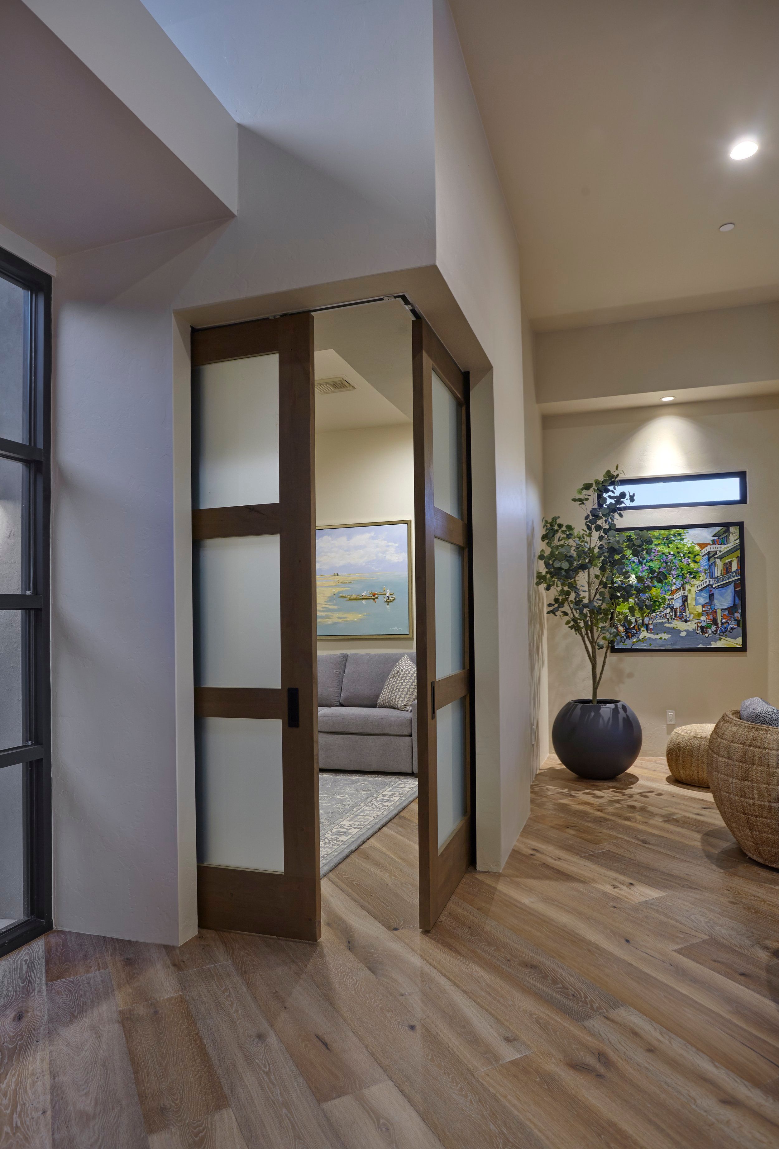 Glass-panelled sliding doors between the hall and a guest sitting room