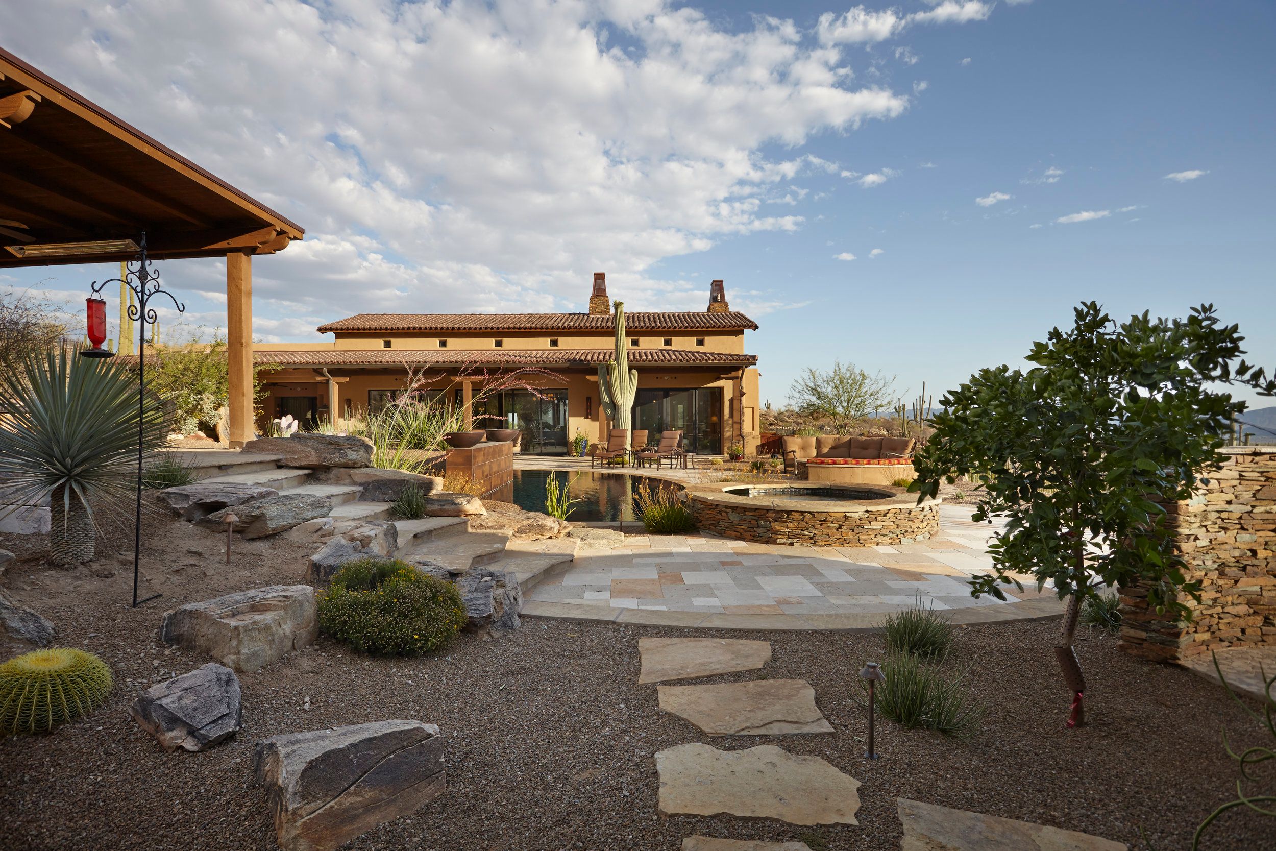 Flagstone path through desert planting toward the covered patio and spa