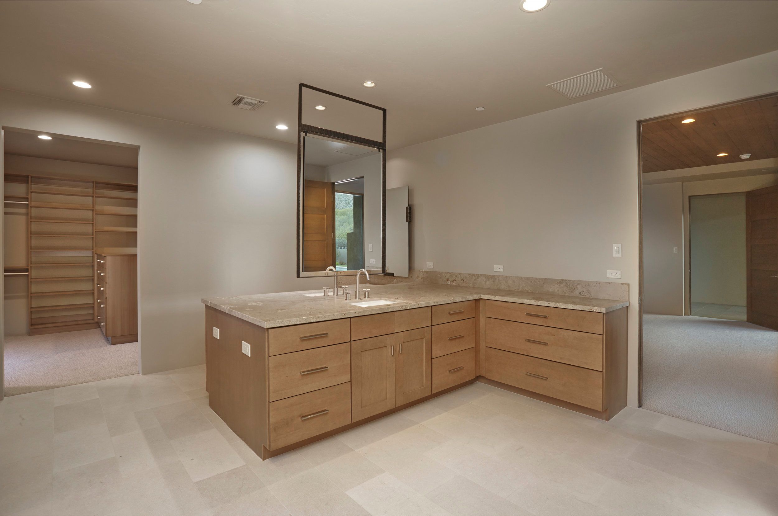 Double vanity island in the primary bathroom with a framed mirror