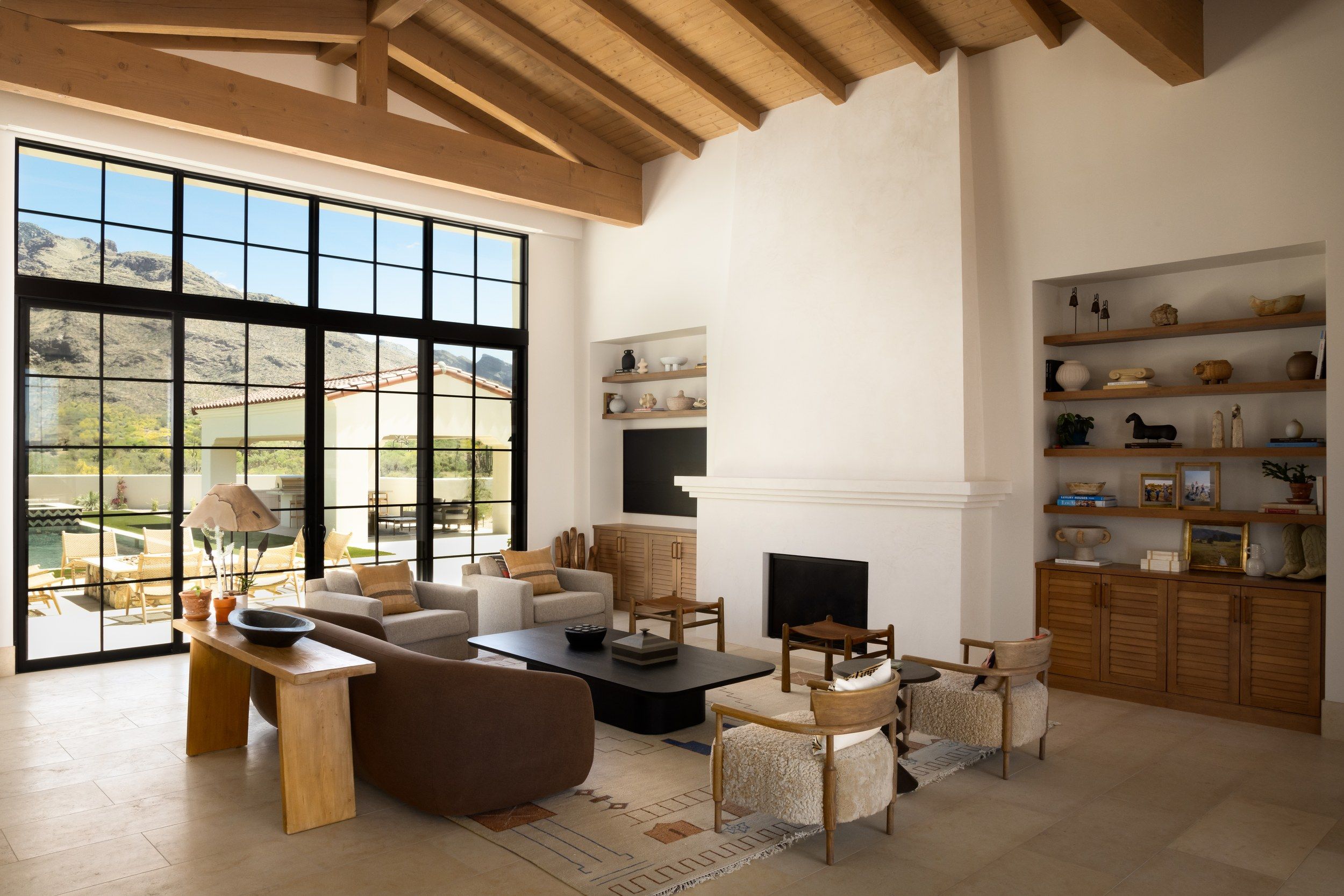 Living room with exposed beams, steel windows and built-in shelving