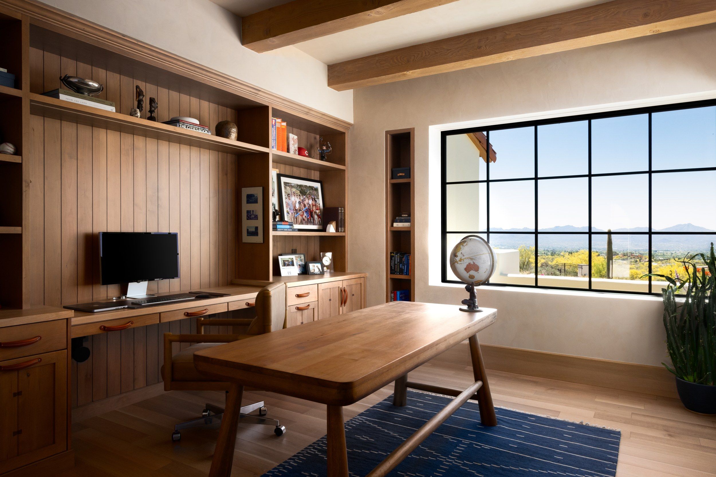 Study with a timber-panelled wall, built-in desk and a mountain view