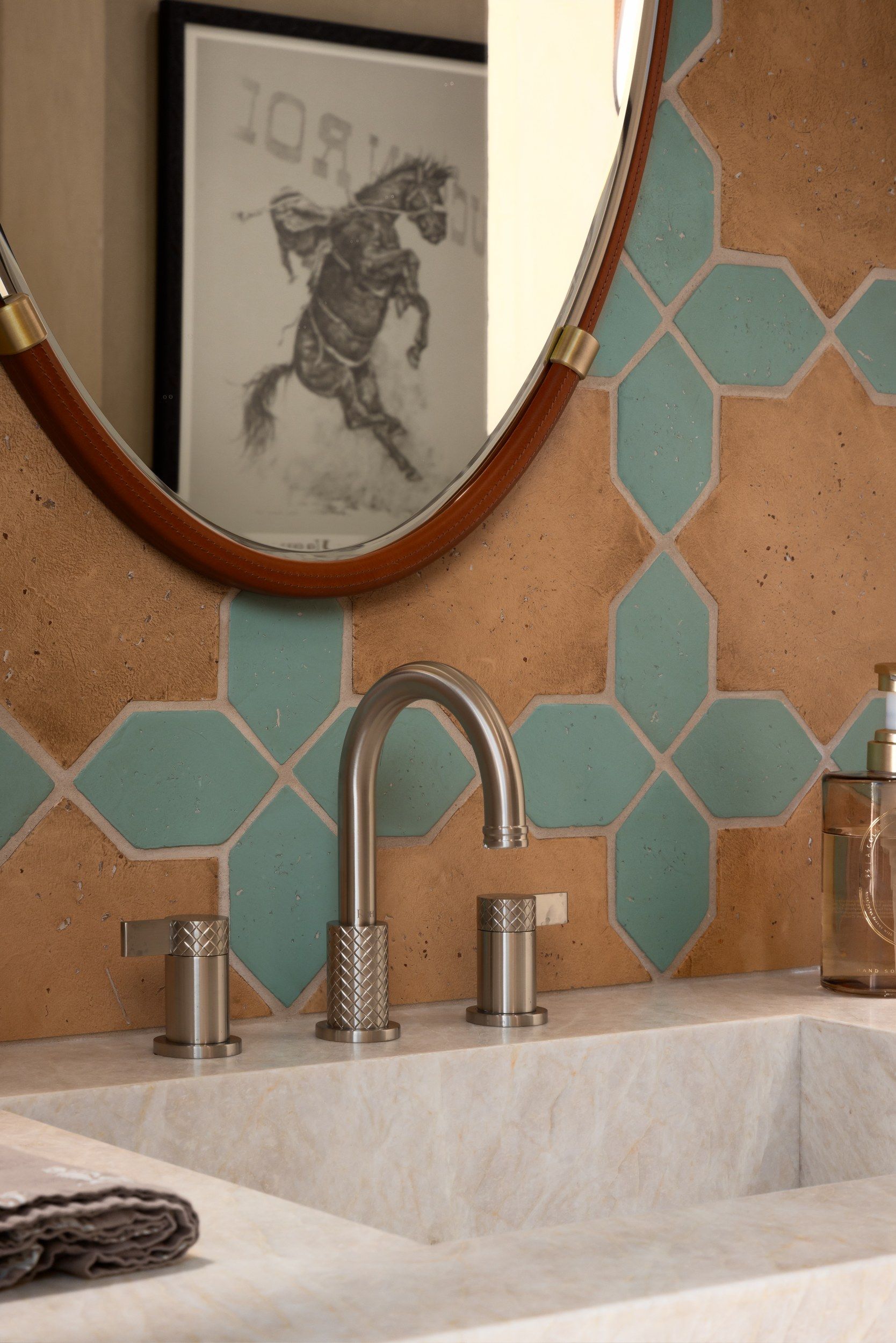 Detail of the powder room tile, stone basin and round mirror