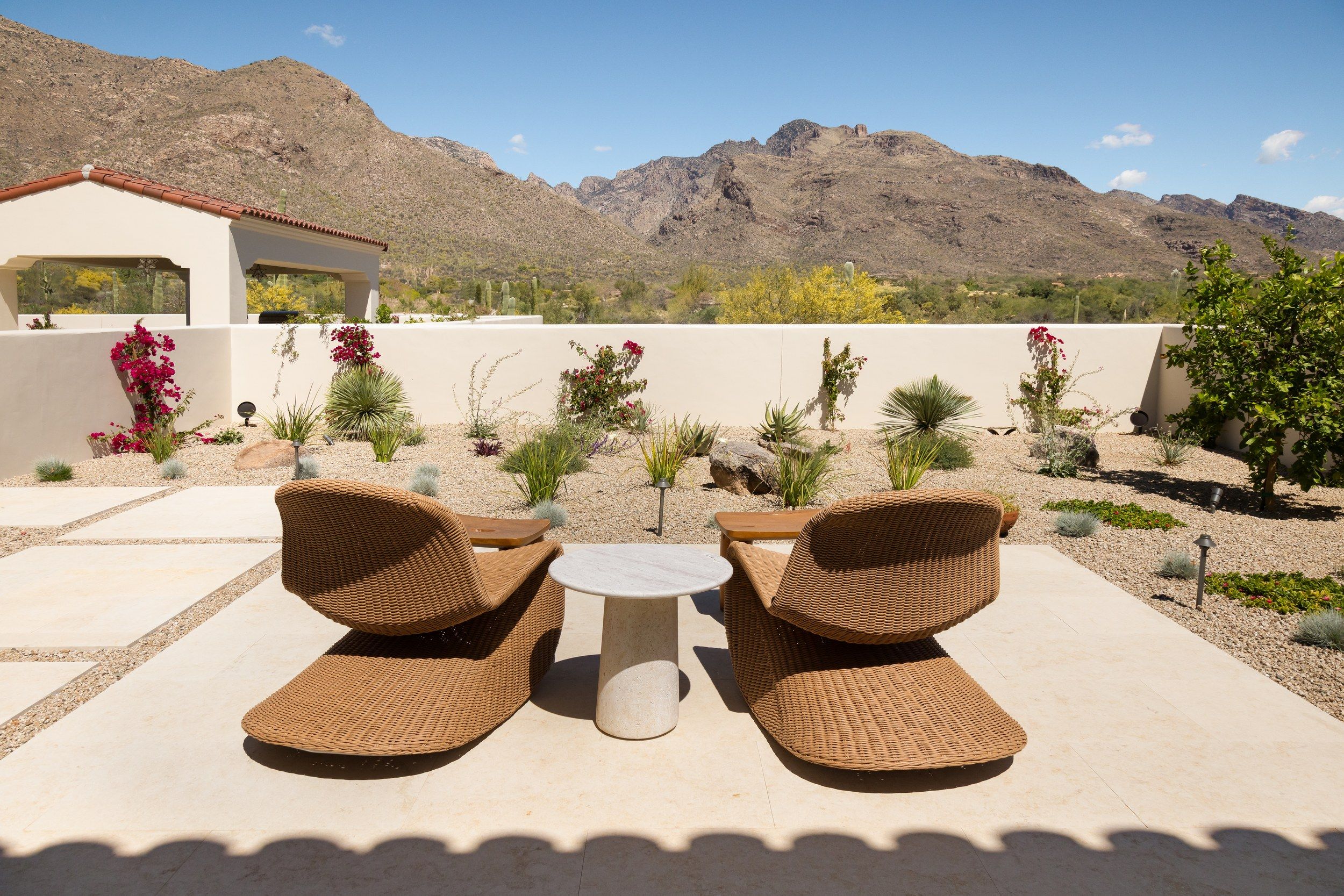 Walled courtyard with woven loungers and the Catalina Mountains beyond